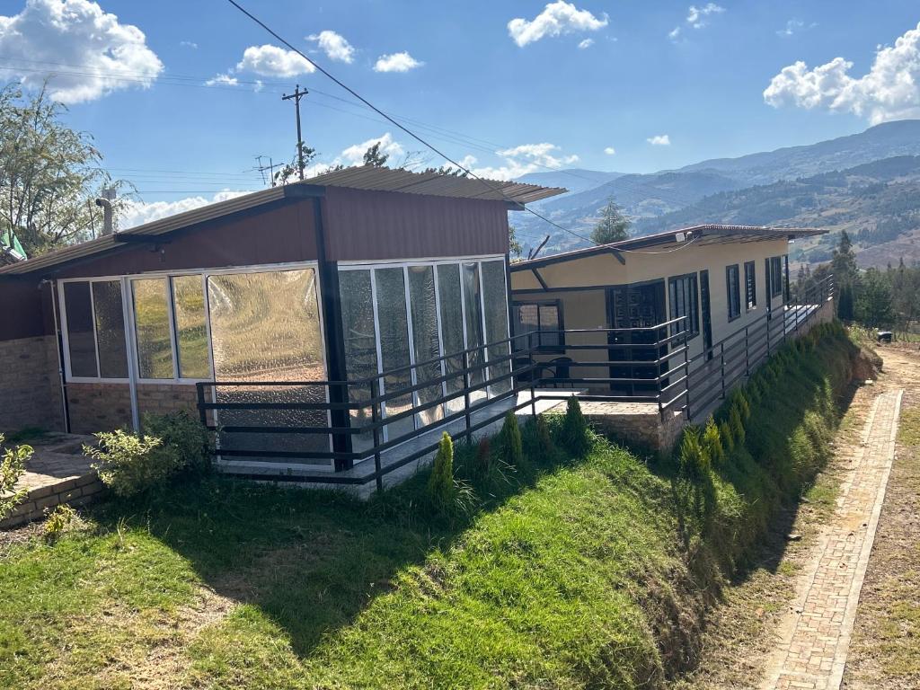 ein Haus auf einem Hügel mit Bergen im Hintergrund in der Unterkunft Chalet Íntimo con Jacuzzi interior ! Delpilar in Sogamoso
