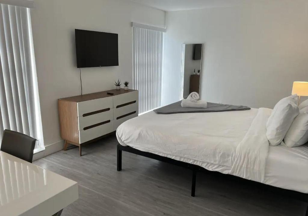 a bedroom with a bed and a dresser with a television at Designer River View Apartments in Fort Lauderdale