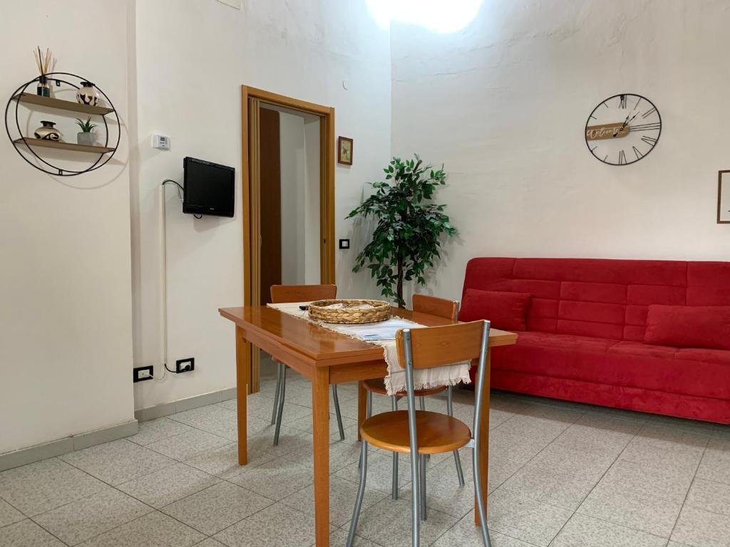 sala de estar con mesa y sofá rojo en Appartamento tranquillo a due passi dal centro, en Vigevano