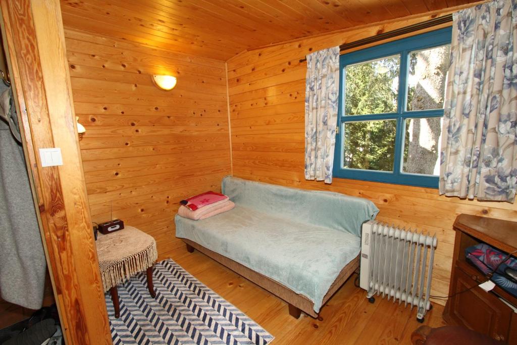 Habitación con sofá en una cabaña de madera en Dom nad jeziorem Dadaj BISKUPIEC, en Wilimy