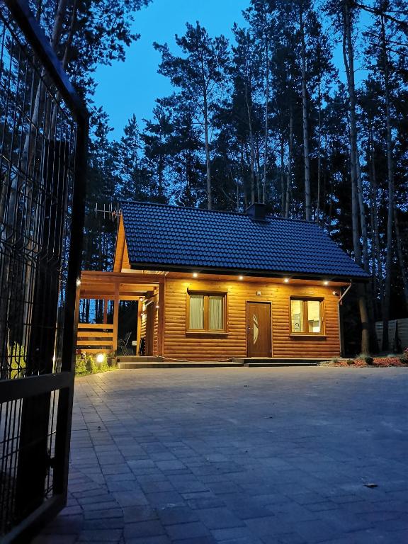 a log cabin with a gate in front of it at Domki Pod Sosnami in Raków