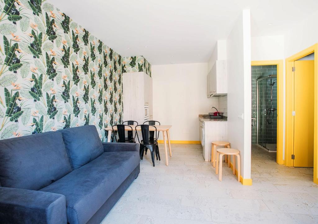 a living room with a blue couch and a table at Apartamentos surfing San Vicente II in San Vicente de la Barquera