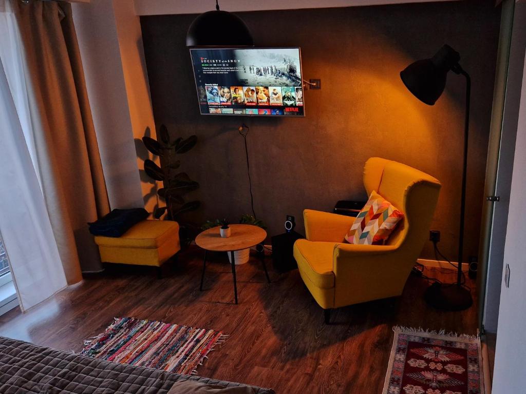 ブカレストにあるFREE PARKING & Self Check-IN WestSide Studio Near the Lake, Lacul Morii, Near Metro Stations Sector 6のリビングルーム(黄色い椅子、テーブル付)