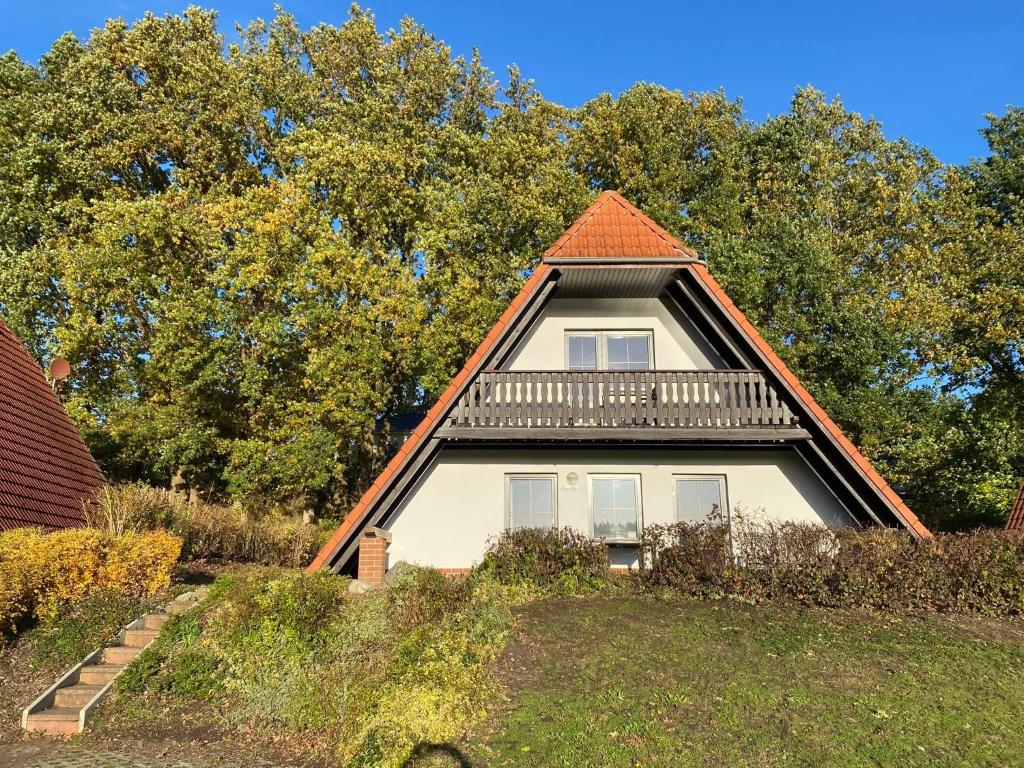 ein Haus mit einem Gamer-Dach und einem Balkon in der Unterkunft Finnhäuser am Vogelpark - Haus Lisa in Marlow