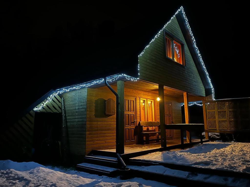 uma casa com luzes de Natal ao lado em Pirts māja Lilijas em Baldone
