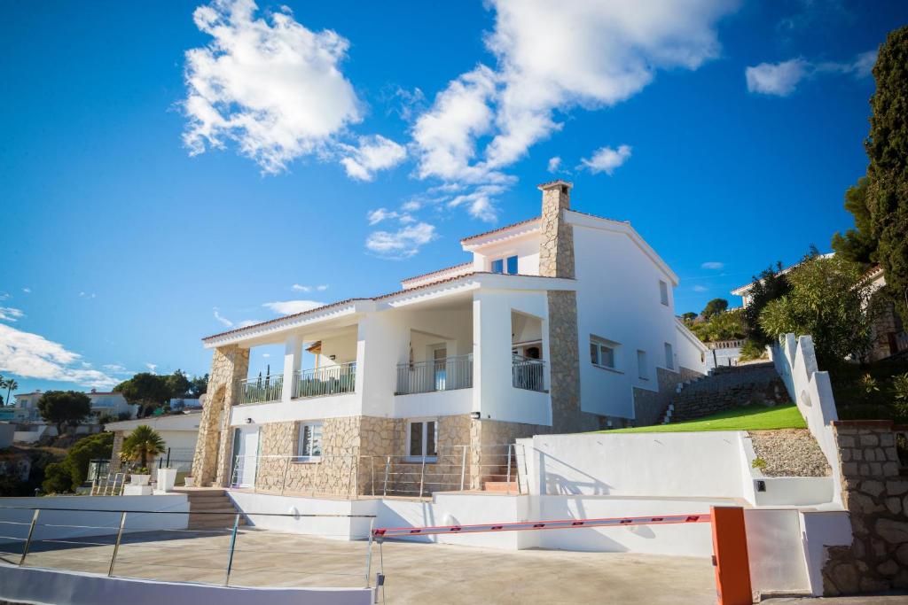 een groot wit huis met een blauwe lucht bij Luna dreams in Peñíscola