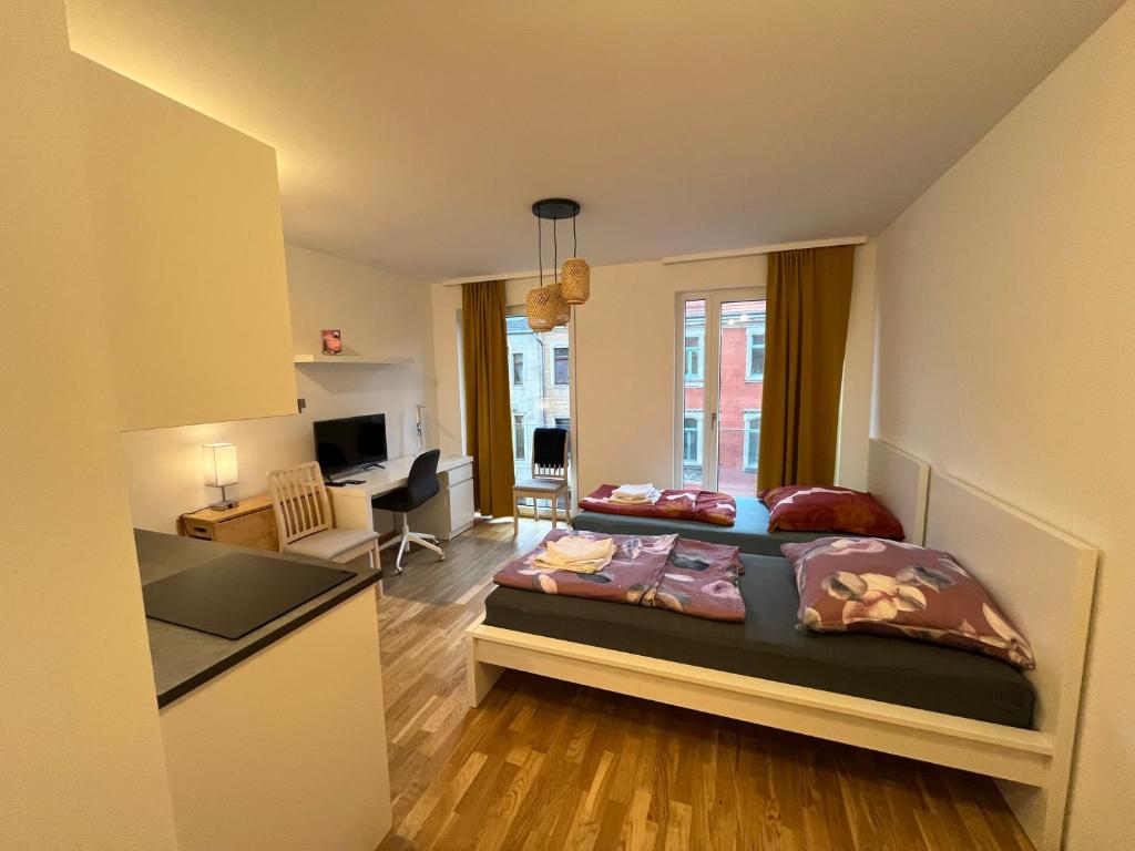 a bedroom with two beds and a living room at New Business Apartment Nr.21 in Dresden