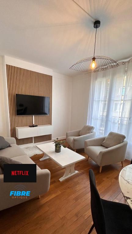 un salon avec deux canapés et une télévision dans l'établissement Le beau Milo 2 chambres Coeur de ville avec Balcon Netflix, au Creusot