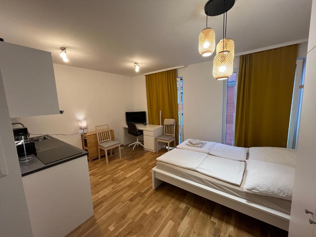 a bedroom with a bed and a kitchen with a desk at New Business Apartment Nr.15 in Dresden