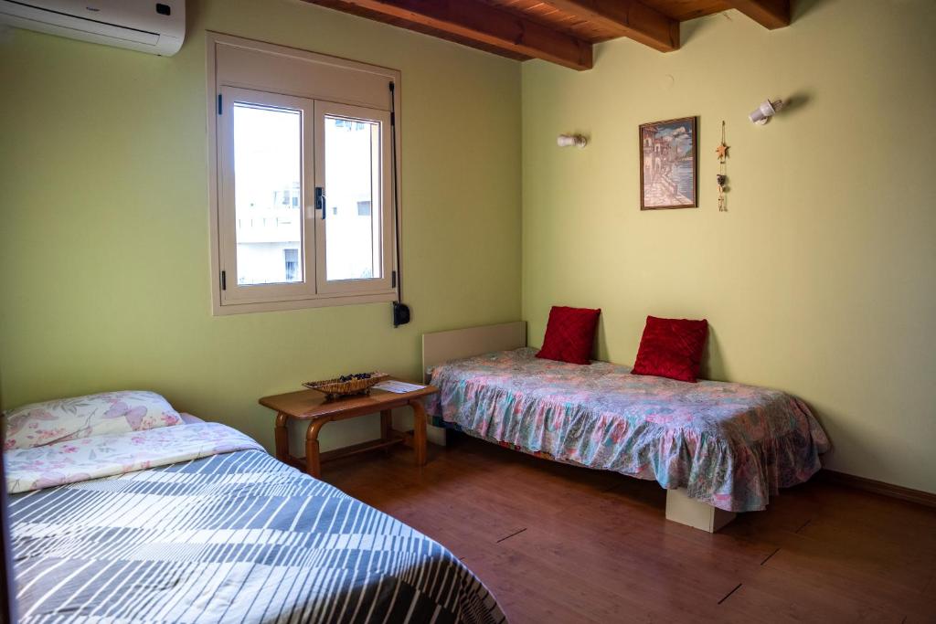 um quarto com duas camas e uma mesa e uma janela em Fani's Family House em Ierápetra