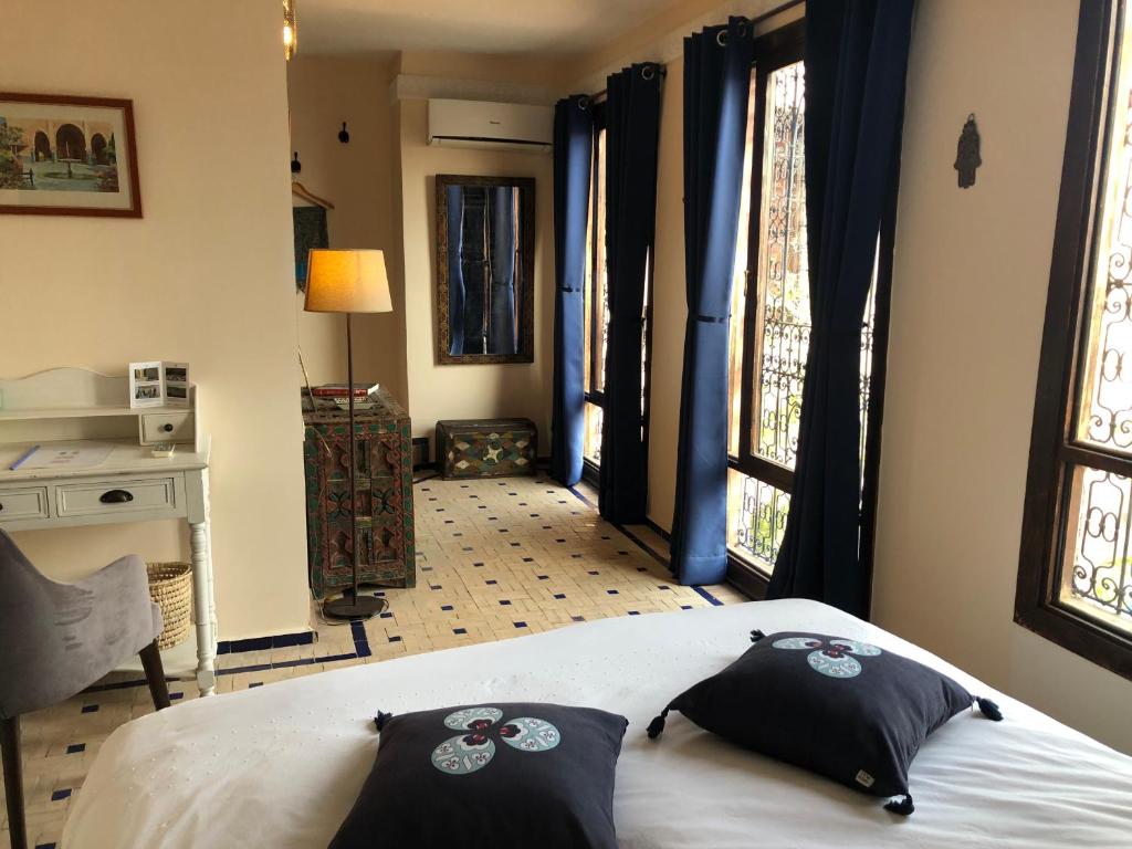 um quarto com uma cama com duas almofadas em Riad Inaya Fez em Fez