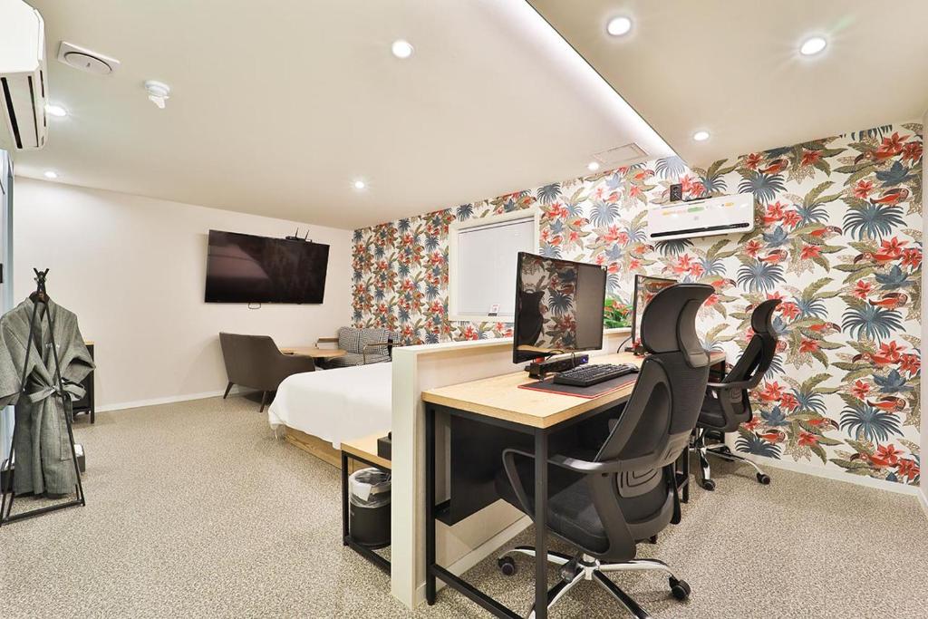 a bedroom with a bed and a desk with a computer at Jamsil Tomgi Hotel in Seoul