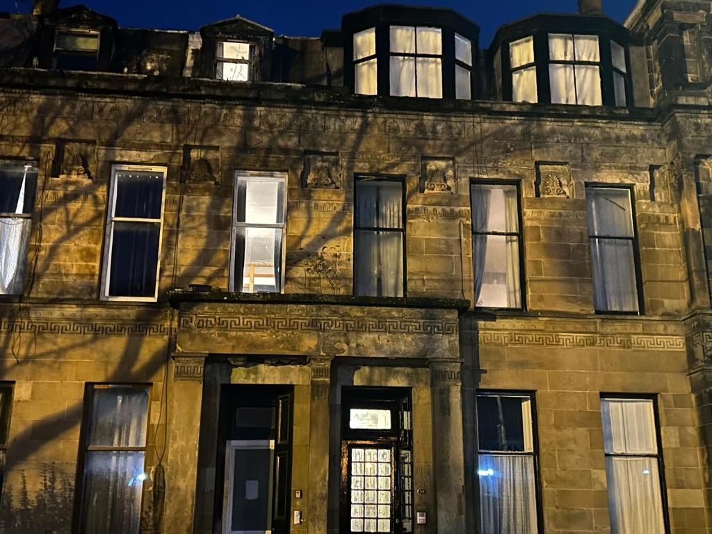 Un vieux bâtiment avec quelques fenêtres. dans l'établissement Alexander Greek Thomson Apartment, à Glasgow