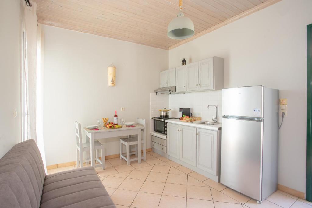 a kitchen with a stainless steel refrigerator and a table at Romanza Studios in Vasiliki