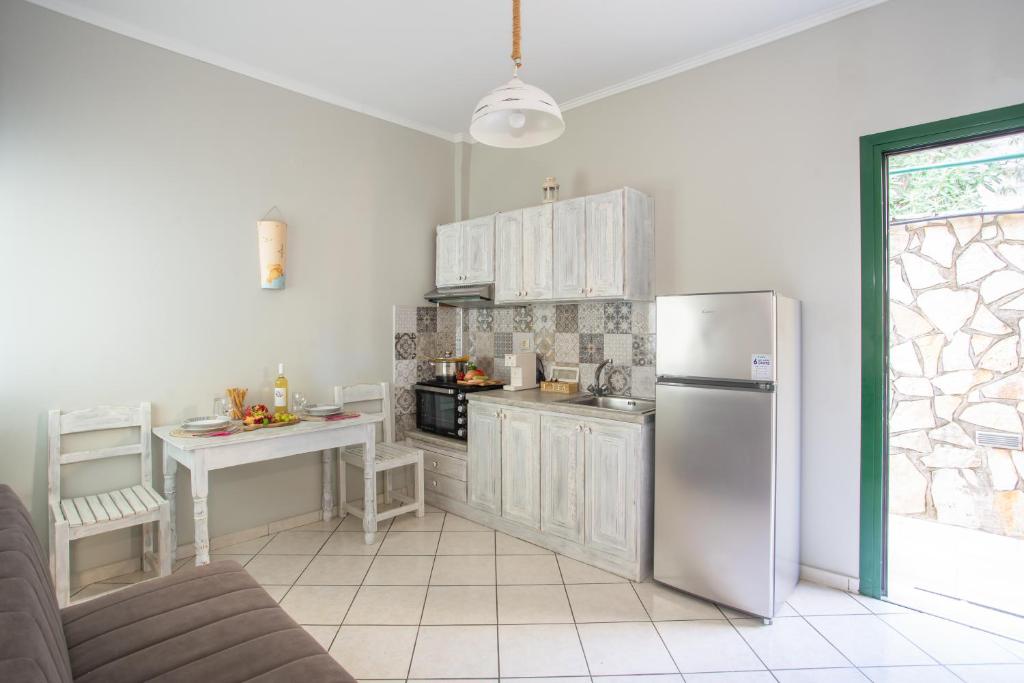 a kitchen with a stainless steel refrigerator and a table at Romanza Studios in Vasiliki