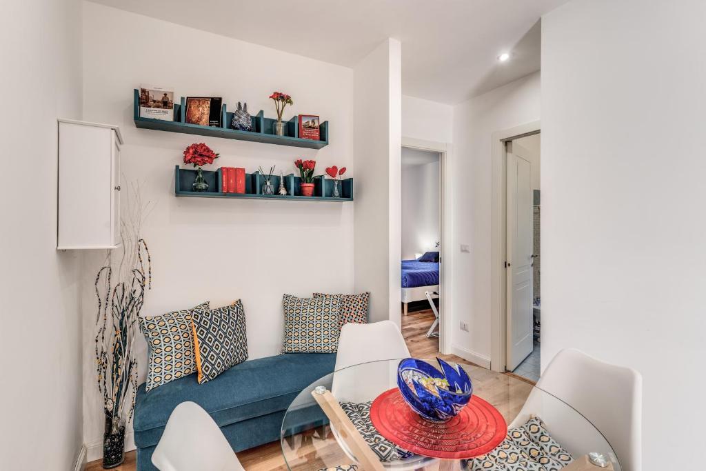 a living room with a blue couch and white chairs at COSY FLAT CINECITTA' in Rome