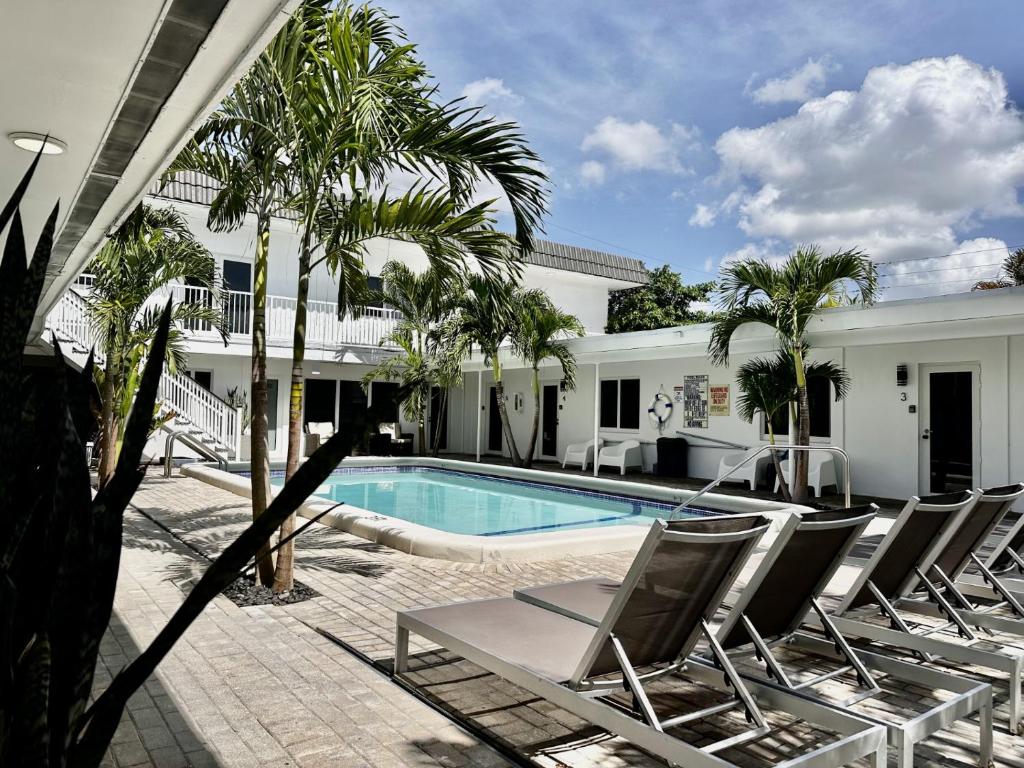 a pool with chaise lounge chairs next to a house at Sapphire by the Sea in Fort Lauderdale