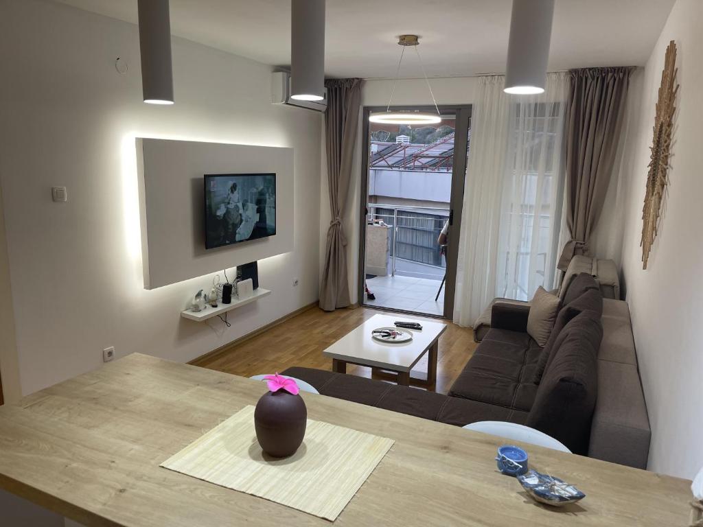 een woonkamer met een bank en een tafel bij Apartament L Blue Horizont Przno in Budva