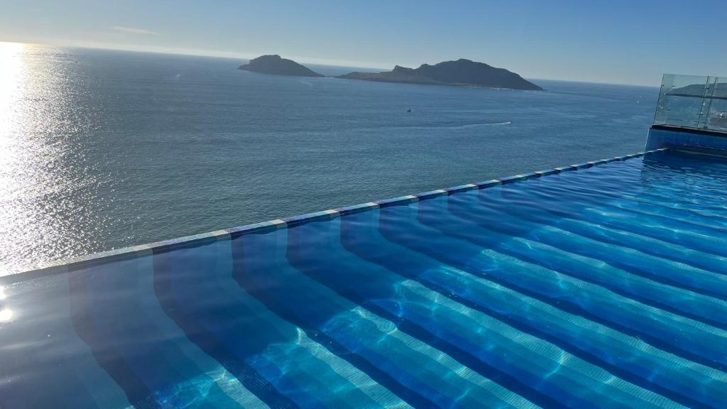 a swimming pool with a view of the ocean at Mar Laguna Hotel in Mazatlán