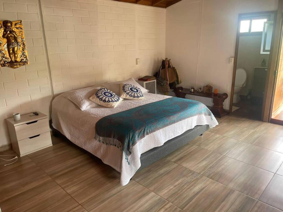 una camera da letto con un letto con cuscini sopra di Hermosa Cabaña a Valparaíso