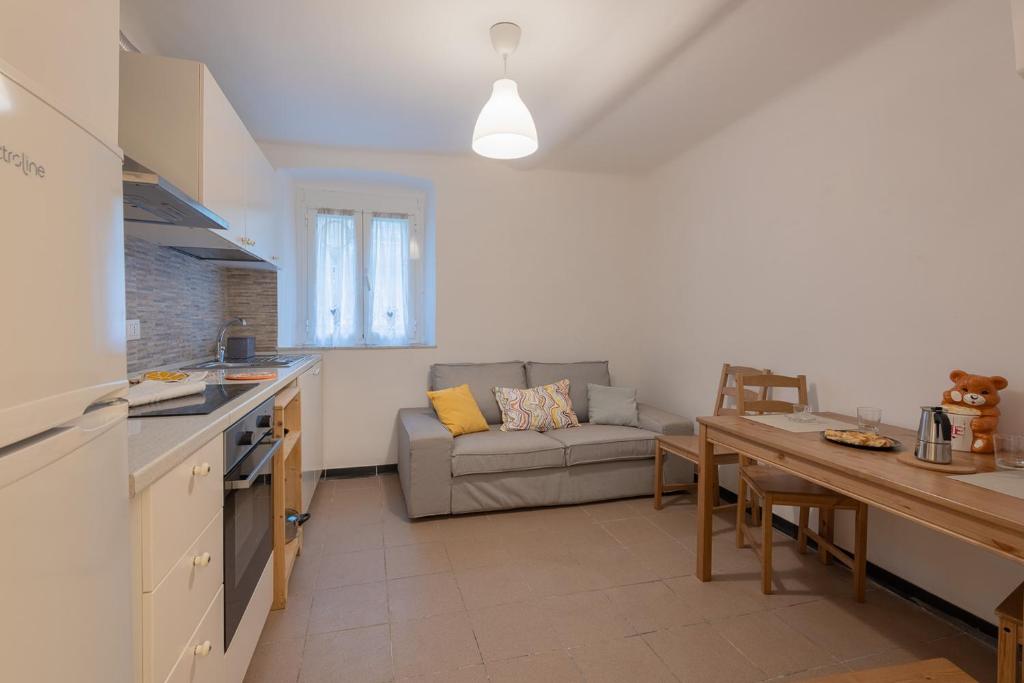 eine Küche und ein Wohnzimmer mit einem Sofa und einem Tisch in der Unterkunft Appartamento San Rocchino 37 - Affitti Brevi Italia in Genua