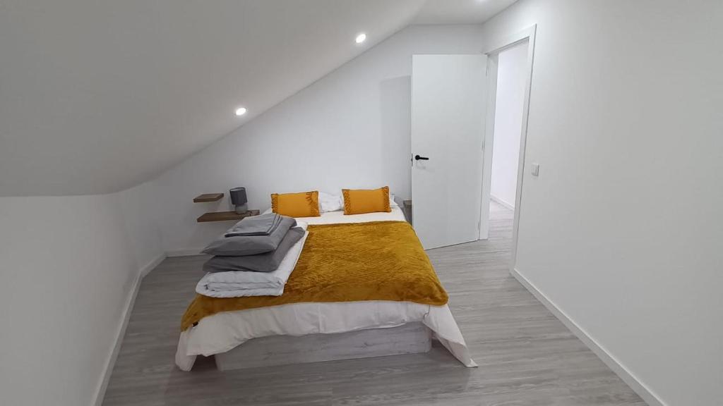 Habitación blanca con cama con manta amarilla en Sunrise Bay - Modern Flat with stunning views, en Seixal