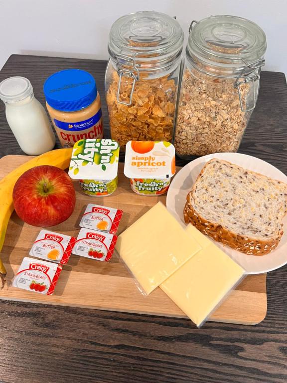 a wooden cutting board with ingredients for peanut butter and oats at The perfect getaway for two in a large suite in Whanganui