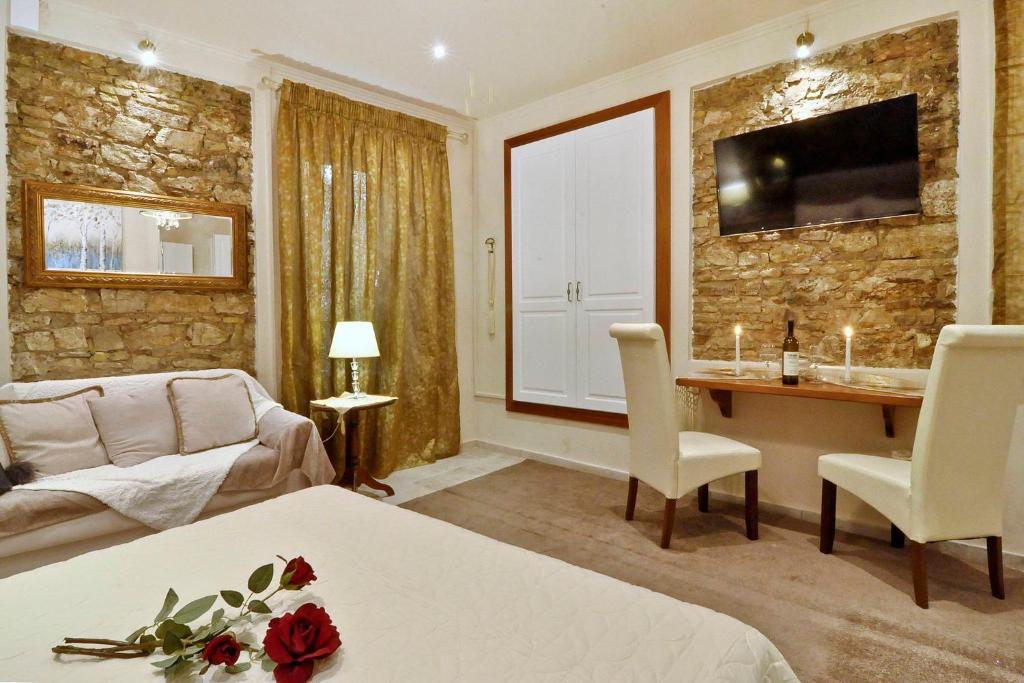 a hotel room with a bed and a table and a couch at Venetian Suite Mitropolis new in Corfu