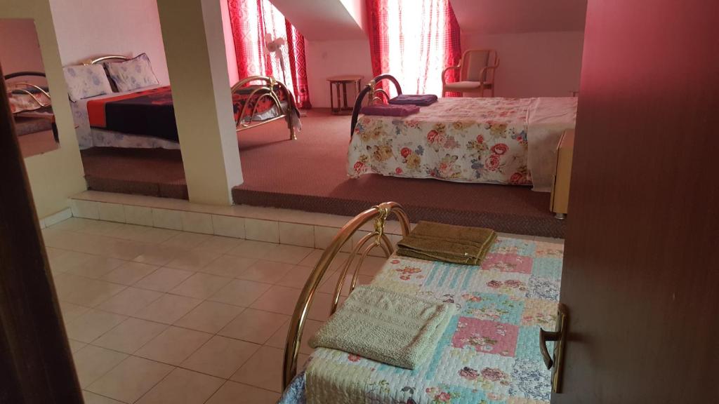 a room with two beds and a table in a room at #11 princess apartments, 230mt to senegambia strip in Sere Kunda