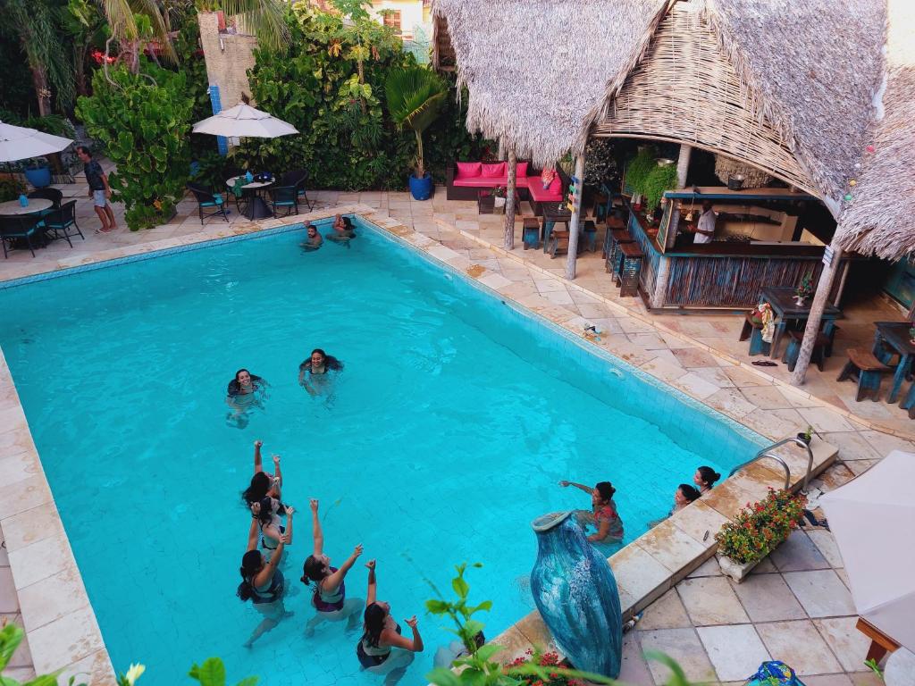 un grupo de personas en la piscina de un complejo en Hotel de Charme Castelinho, en Canoa Quebrada