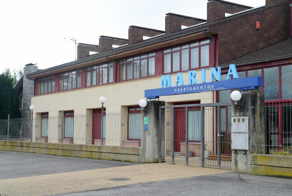 un edificio del puerto deportivo con un cartel en el costado en Apartamentos Marina, en Naveces