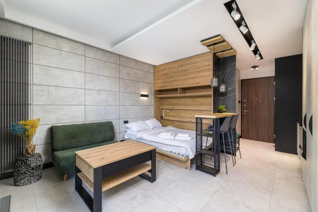 a bedroom with a bed and a couch and a table at Cozy Modern Corner by ECRU WWA59 in Warsaw