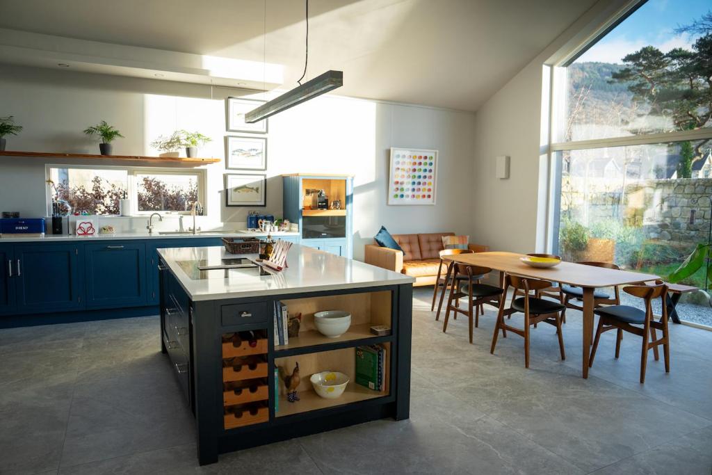New build eco house in walled garden, Rostrevor في روستريفور: مطبخ مع طاولة وغرفة طعام