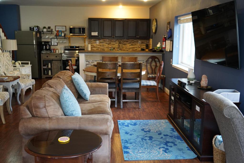a living room with a couch and a table and a kitchen at Walkout Basement Near Creation Museum in Hebron