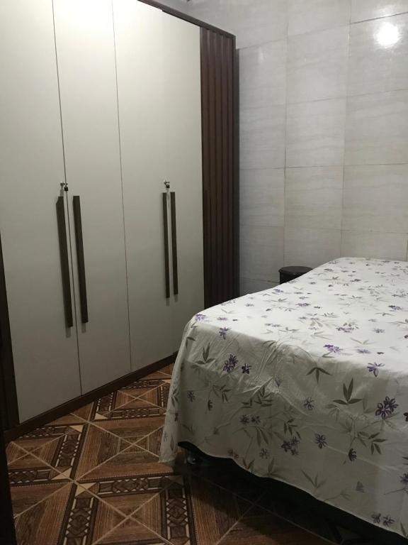 a bedroom with a bed and white cabinets at Michele in São Pedro da Aldeia