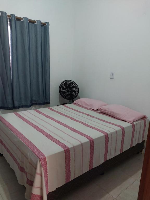 um quarto com uma cama com um cobertor listrado em Casa em Pradim de açúcar em Prado