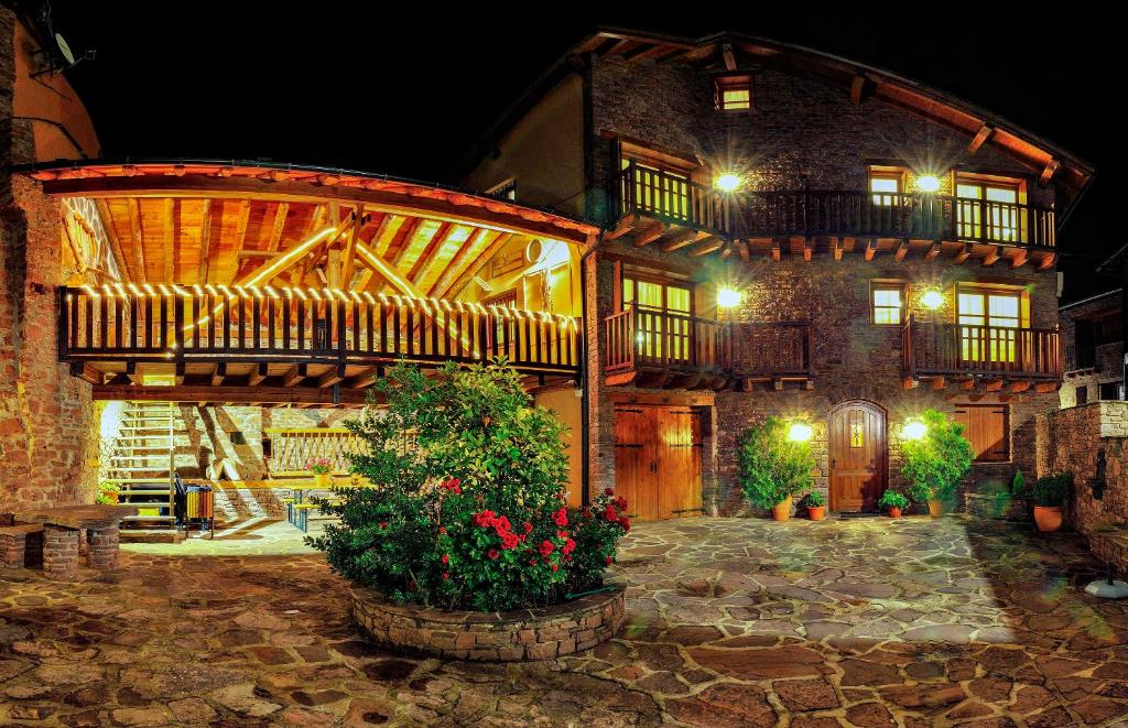 a large brick building with a balcony and flowers at Turisme Rural Lo Pallé de Cal Bosch in Llagunes