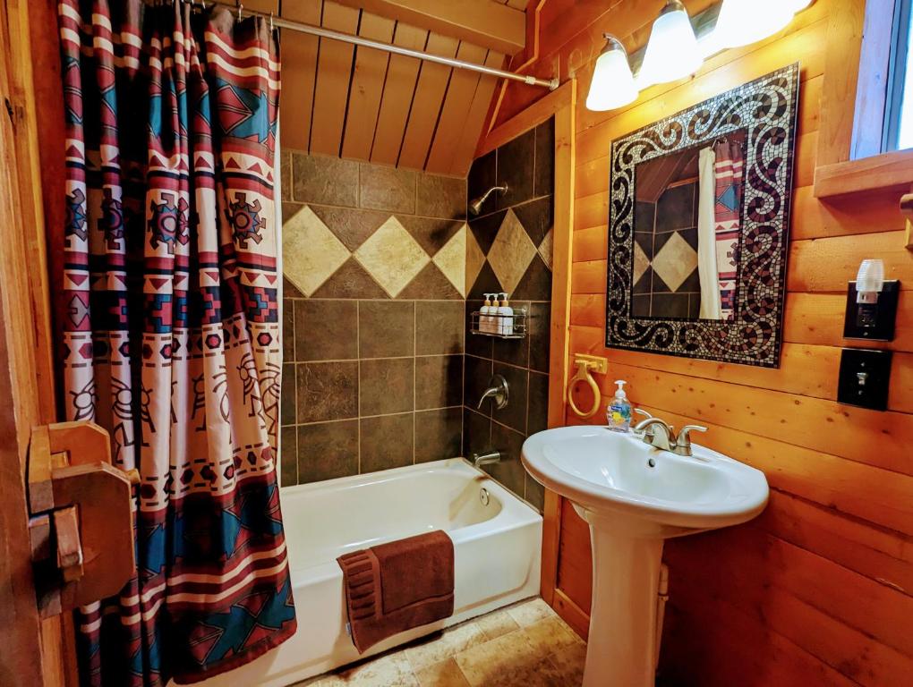 bagno con lavandino, vasca, servizi igienici e lavandino di Kingman KOA a Kingman