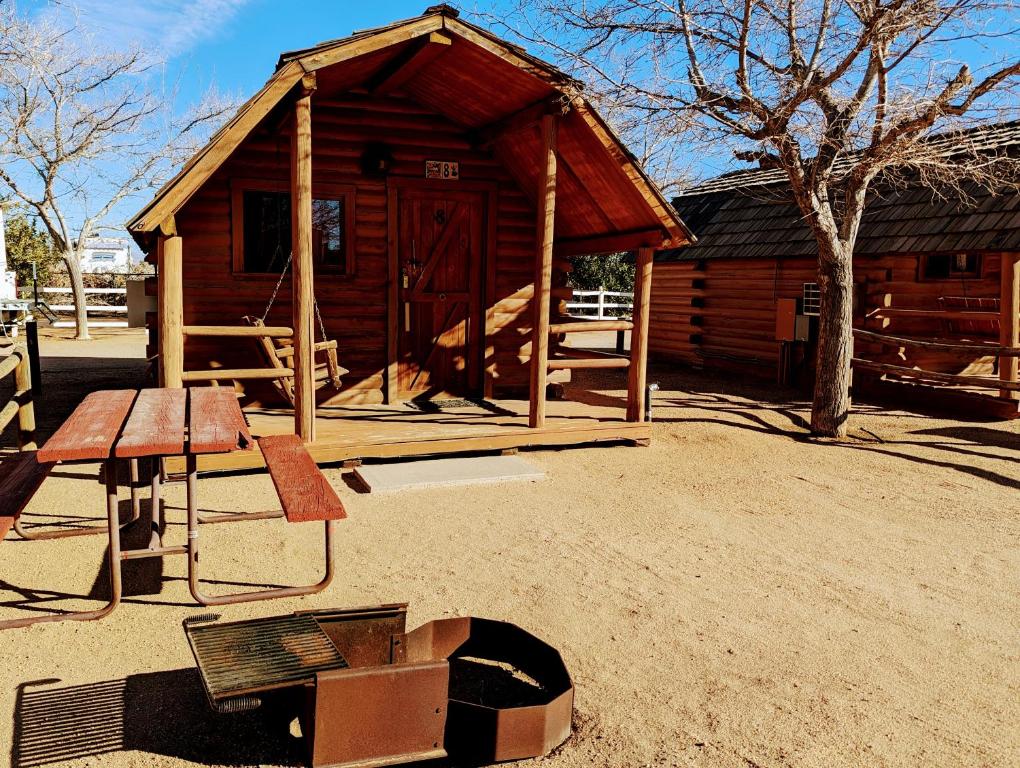 una cabina in legno con tavolo e panca di Kingman KOA a Kingman