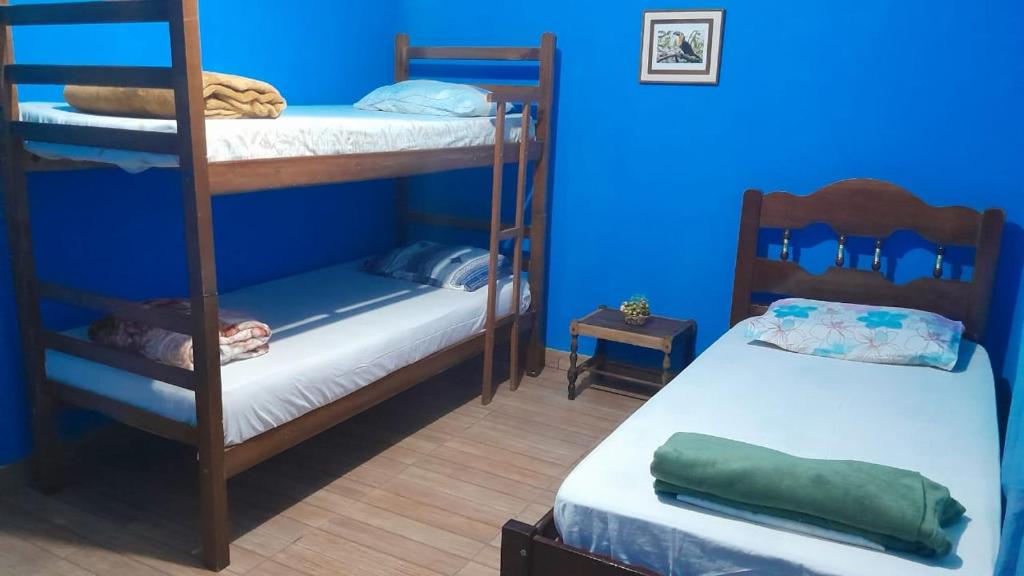 伊塔蒙蒂的住宿－Casa e camping Reinaldo e Julia recanto das árvores，客房设有两张双层床和蓝色的墙壁。