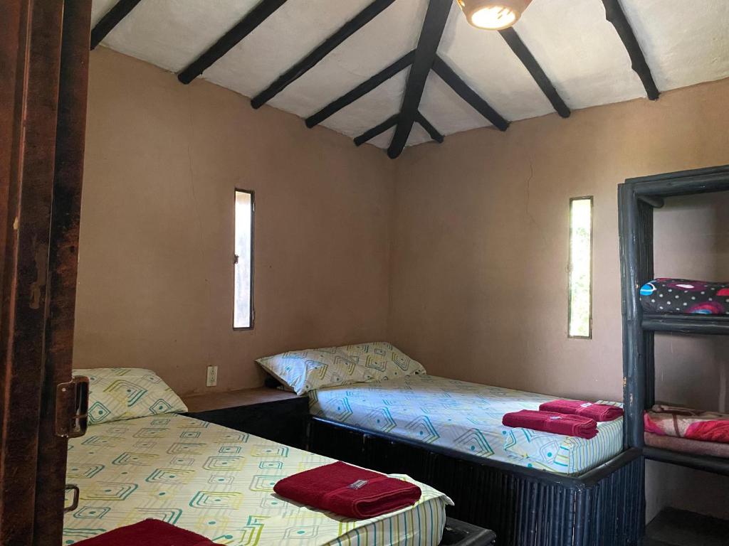 a room with two beds and a mirror in it at Cabañas Cañon Del Chicamocha in Aratoca