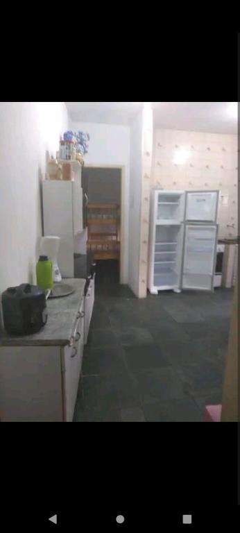 une cuisine avec des placards blancs et un comptoir dans l'établissement Casa com piscina, à Caraguatatuba