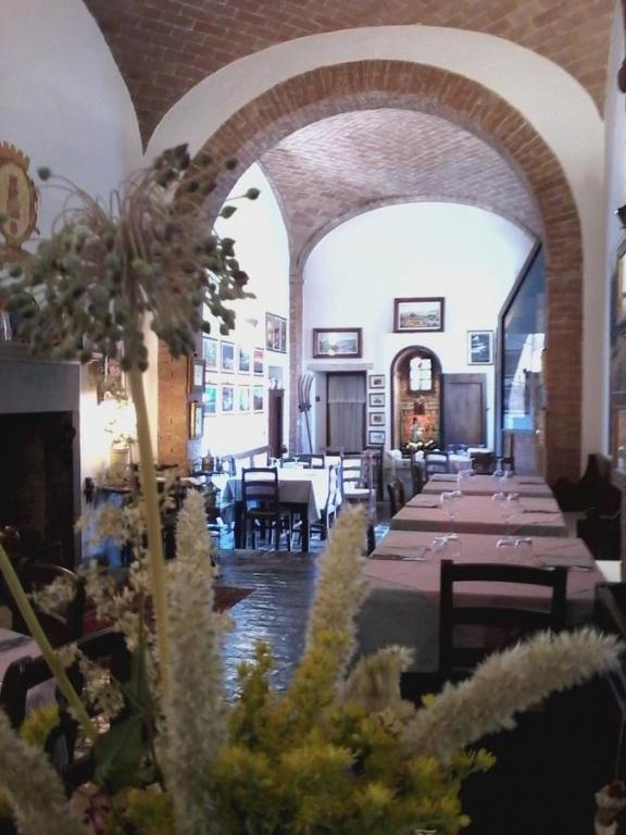 jadalnia ze stołami i krzesłami w budynku w obiekcie Cisterna Nel Borgo w mieście Castiglione dʼOrcia