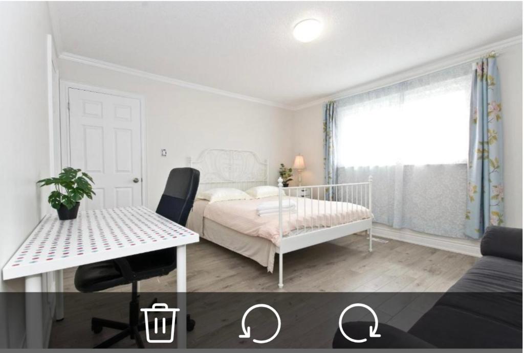 - une chambre blanche avec un lit, une table et une fenêtre dans l'établissement Comfort private house, à Markham