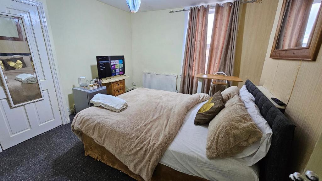a bedroom with a bed with pillows and a television at Beautiful 1-Bed House in Leeds in Leeds