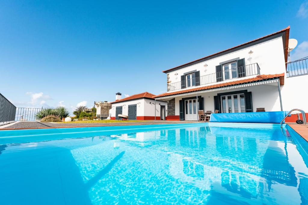 a swimming pool in front of a house at Casa Pereira in Relógio do Poiso