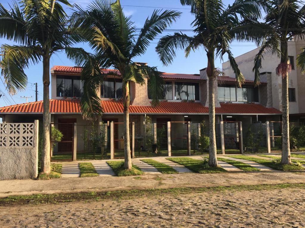 un bâtiment avec des palmiers en face de celui-ci dans l'établissement Sobrados Varuna, à Passo de Torres