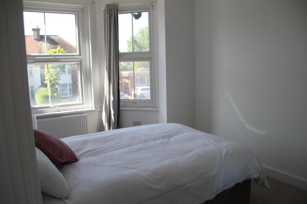 a white bed in a room with two windows at Double Bedroom with Marble private bathroom in Edgware