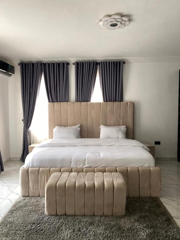 a bedroom with a large bed with a tufted headboard at Luxury 3BR + 3.5bath apartment in Victoria Island with pool in Lagos