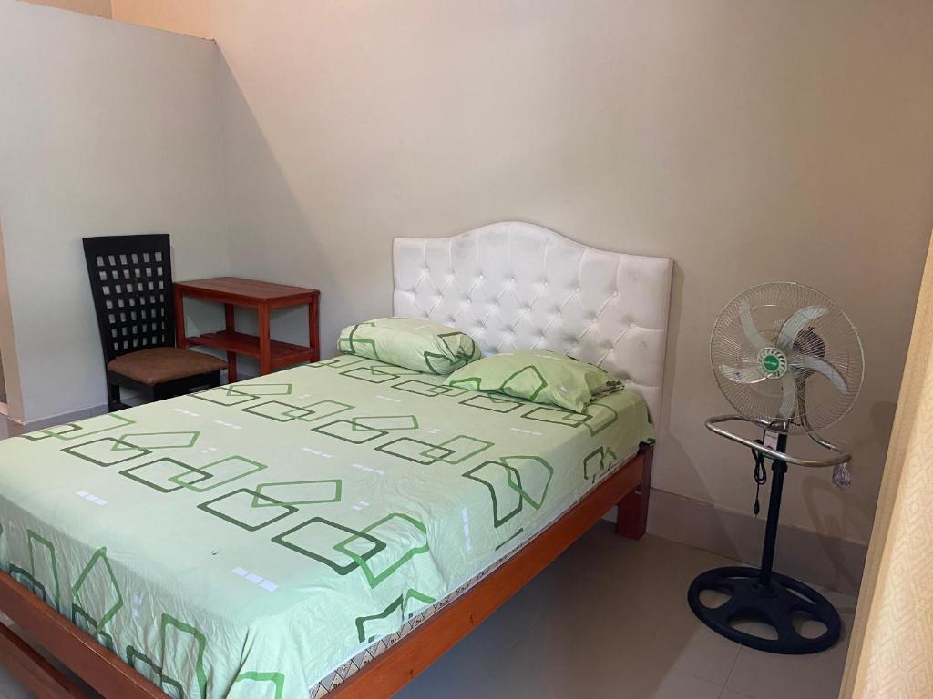 um quarto com uma cama, uma ventoinha e uma secretária em Residencial Carloz em Tarapoto